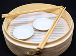Overview of steamer with chopsicks and small sushi dishes